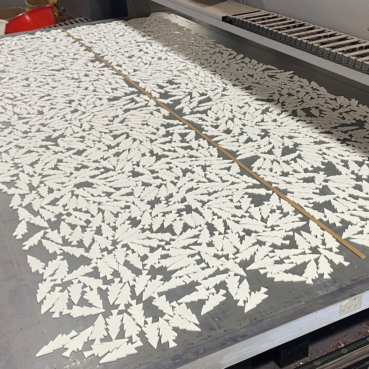 Large batch of small Christmas tree-shaped pieces arranged for UV printing