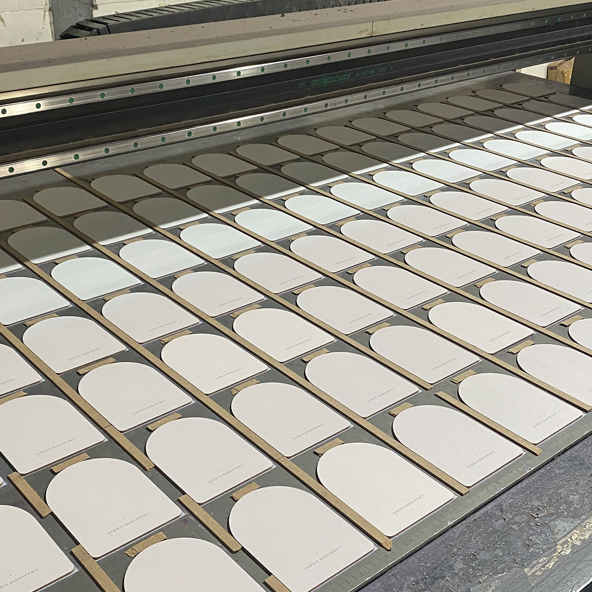 Rows of rounded rectangular blanks arranged for batch UV printing