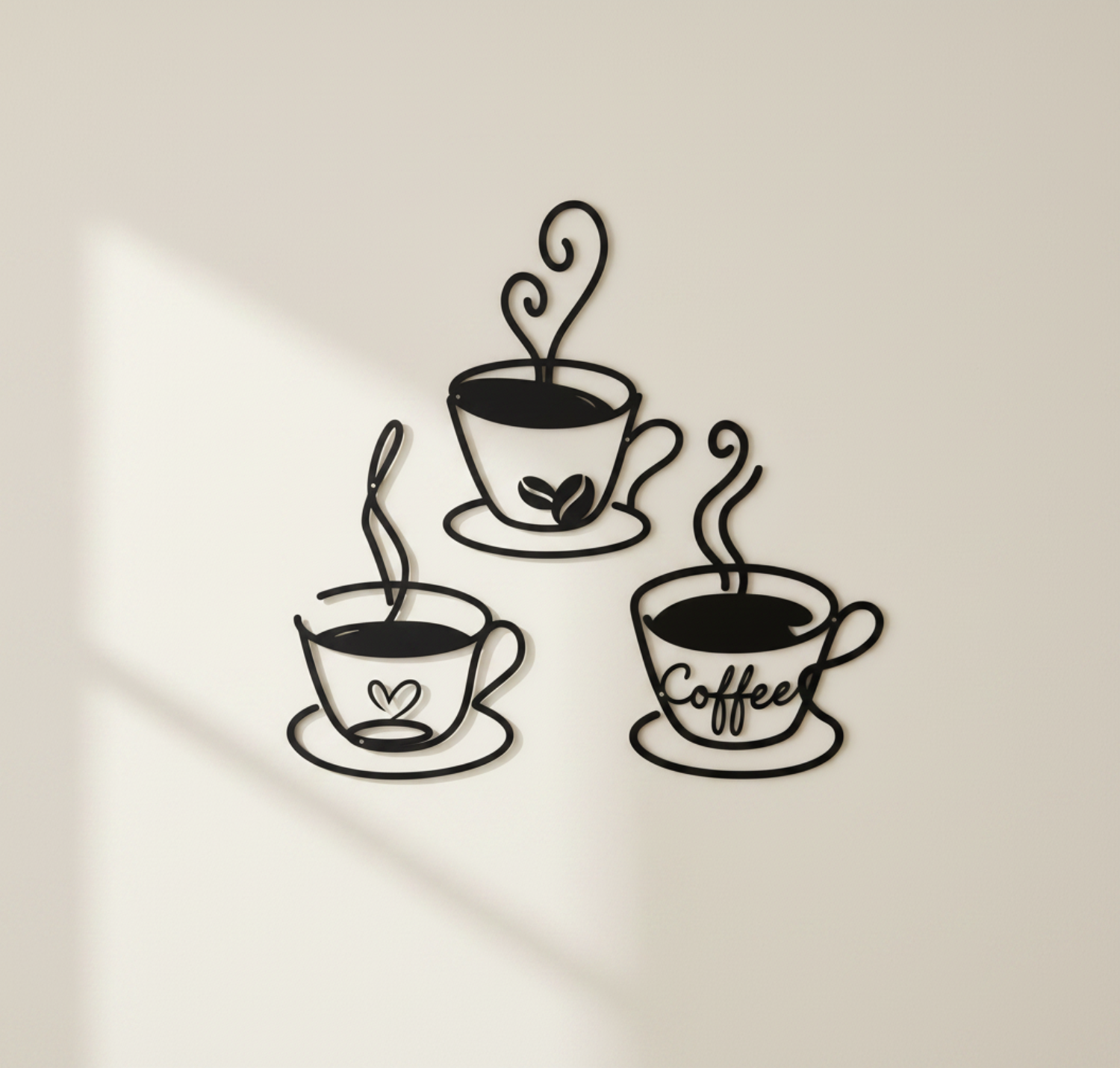 Set of three black metal coffee cup wall decorations displayed on an indoor wall
