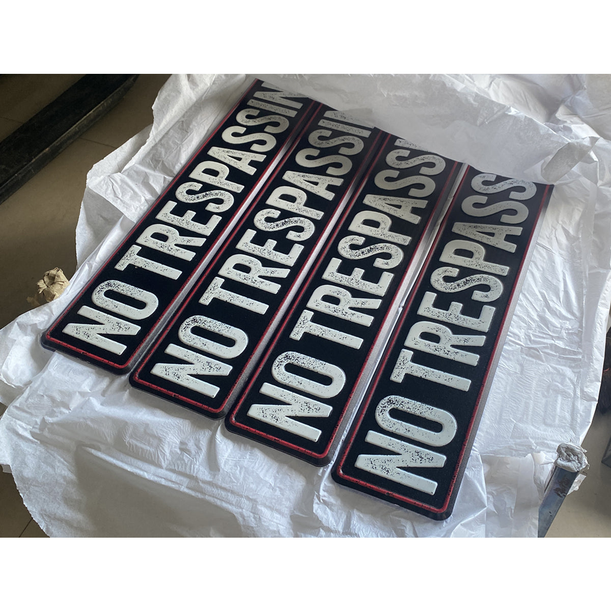 Batch of finished metal no trespassing signs ready for packing