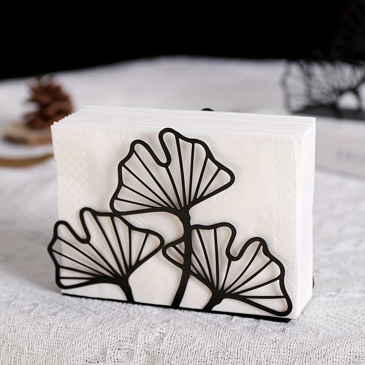 Black metal ginkgo leaf napkin holder displayed on a dining table