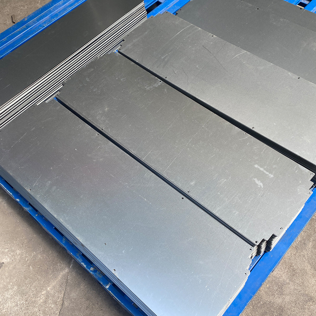 Stacks of finished laser-cut metal panels prepared for the next production step