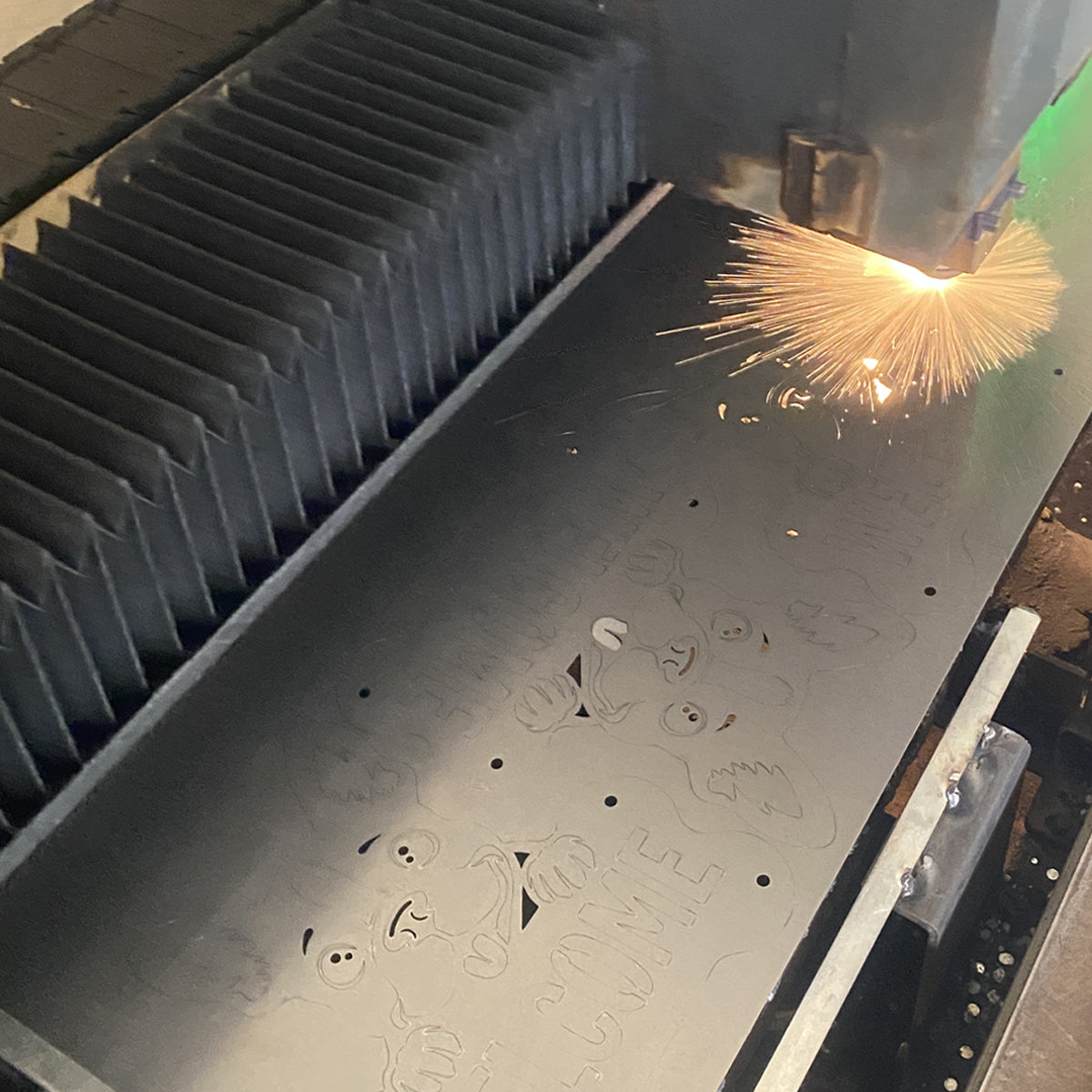 Laser cutting custom dog welcome signs from sheet metal in our workshop