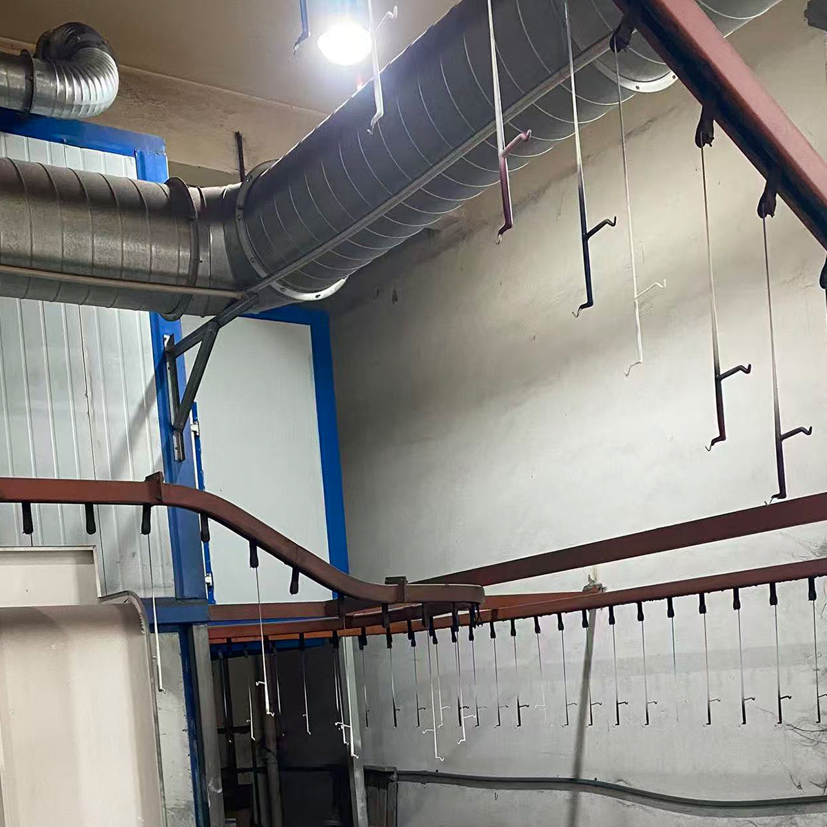 Overhead conveyor line with hanging hooks used for powder coating metal parts