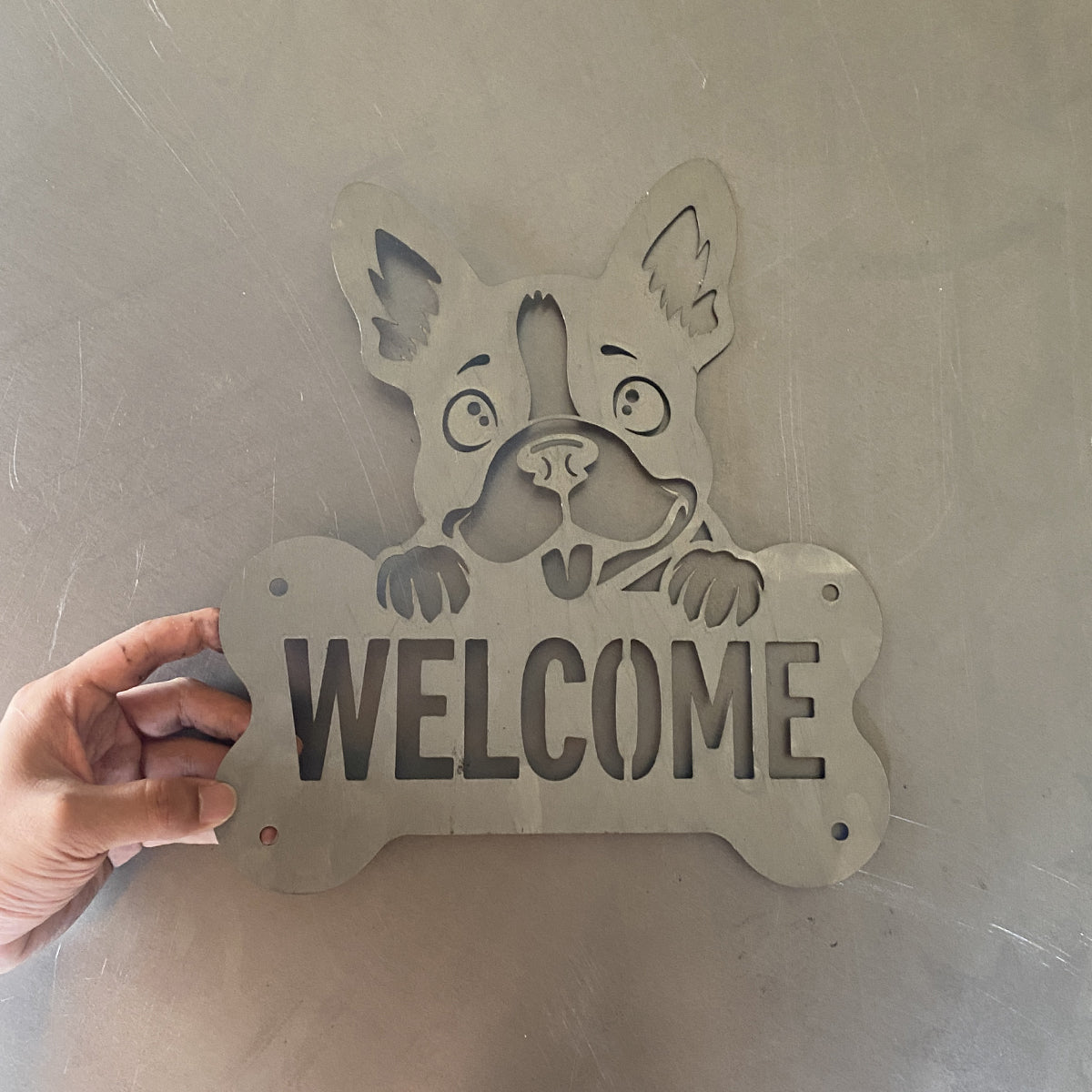 Unfinished laser-cut metal dog welcome wall sign prototype